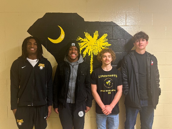 Irmo High School's LifeSmarts team poses in front of an image of the state of South Carolina painted in the school's colors (black and yellow).
